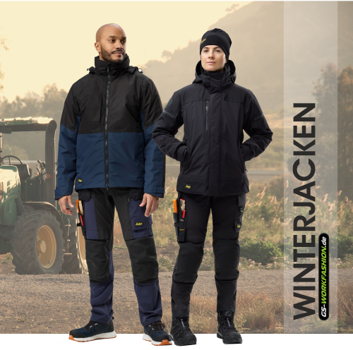 Landwirt in warmer Winterjacke steht auf dem Acker.